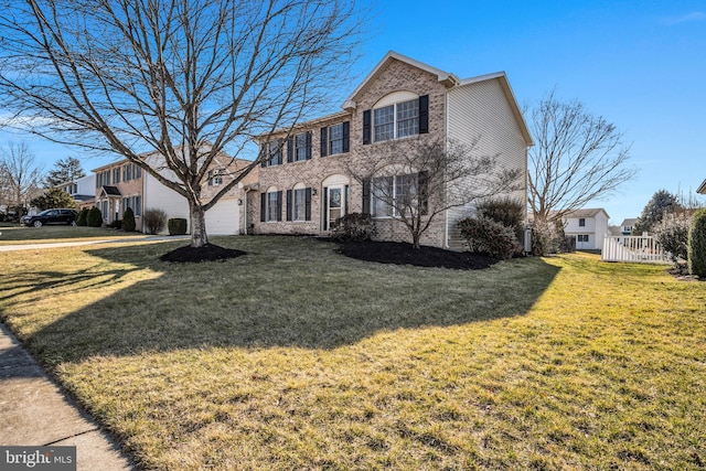 view of front of property with brick siding, a garage, and a front yard