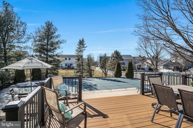 wooden deck with a fenced in pool, fence, a residential view, outdoor dining space, and a patio