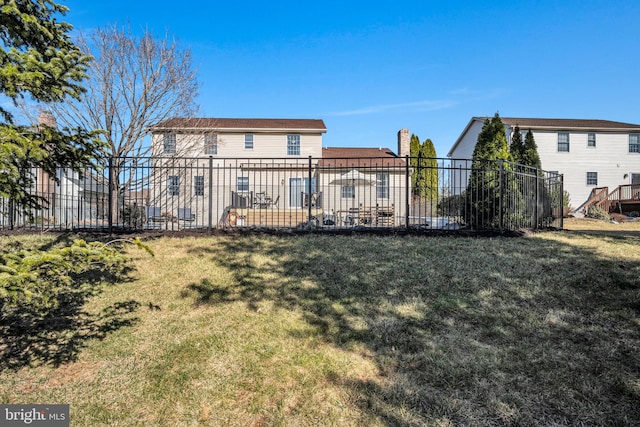 rear view of house featuring a patio, a lawn, and fence