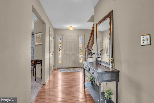 entryway featuring stairway, baseboards, and wood-type flooring