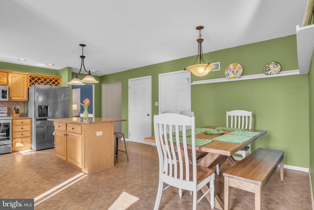 kitchen featuring white microwave, electric stove, fridge with ice dispenser, and light brown cabinetry