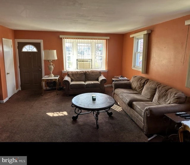 carpeted living area featuring cooling unit and baseboards