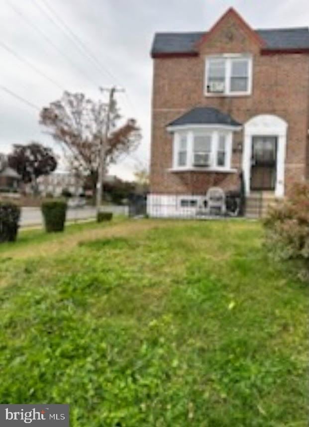 rear view of property featuring a lawn