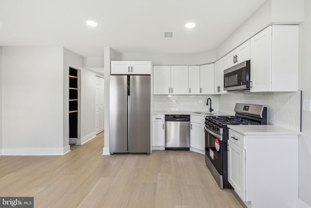 kitchen featuring stainless steel appliances, light wood finished floors, visible vents, and light countertops