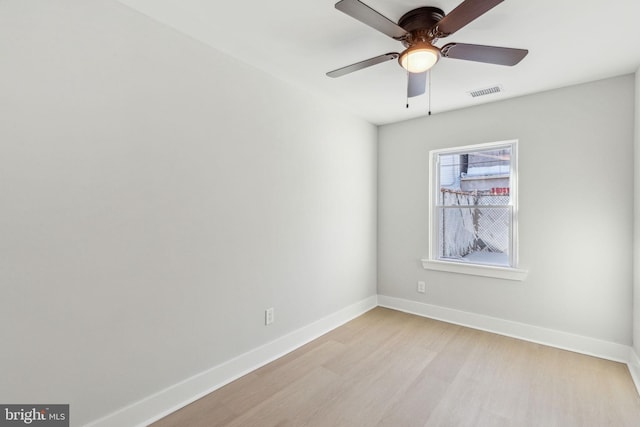 unfurnished room with ceiling fan, light wood-style floors, visible vents, and baseboards