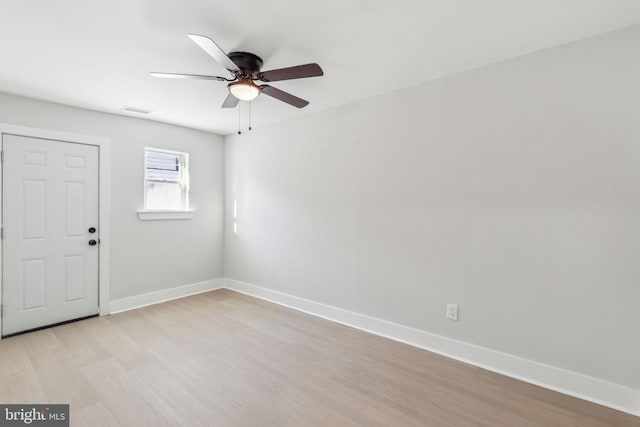 empty room with visible vents, baseboards, a ceiling fan, and light wood finished floors