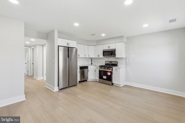 kitchen featuring visible vents, light wood-style floors, appliances with stainless steel finishes, white cabinets, and light countertops