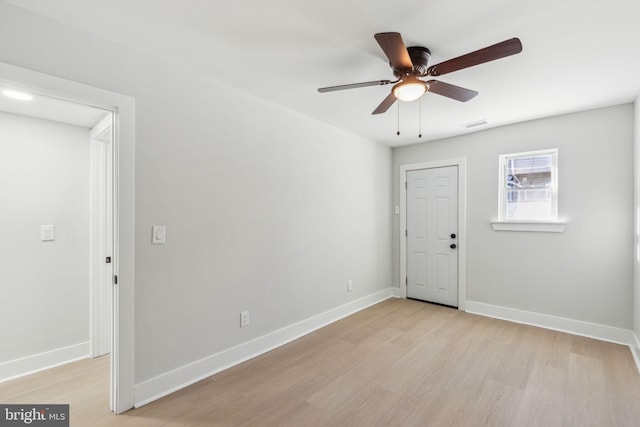 unfurnished room featuring visible vents, a ceiling fan, baseboards, and light wood finished floors