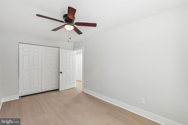 unfurnished bedroom featuring light wood finished floors, ceiling fan, a closet, and baseboards