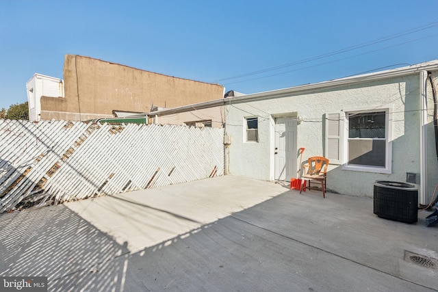 exterior space featuring stucco siding, a patio, central AC unit, and fence