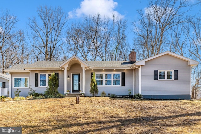 ranch-style house featuring a chimney and a shingled roof