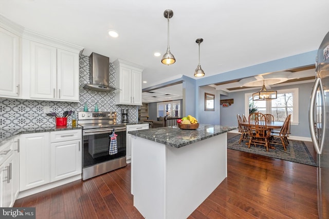 kitchen with dark stone countertops, wall chimney exhaust hood, dark wood-style flooring, and stainless steel appliances