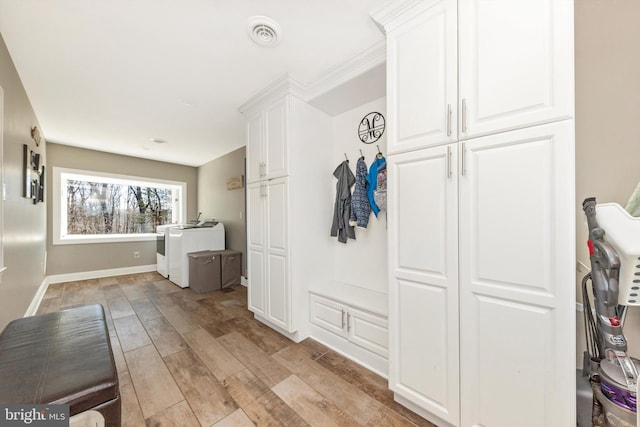 mudroom featuring washer and clothes dryer, visible vents, light wood-type flooring, and baseboards