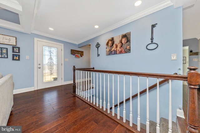 corridor with an upstairs landing, baseboards, wood-type flooring, and ornamental molding