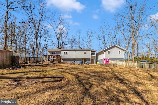 rear view of house featuring a deck, a yard, and fence private yard