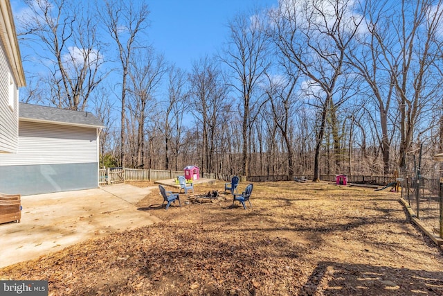 view of yard with a patio area, a fire pit, and fence