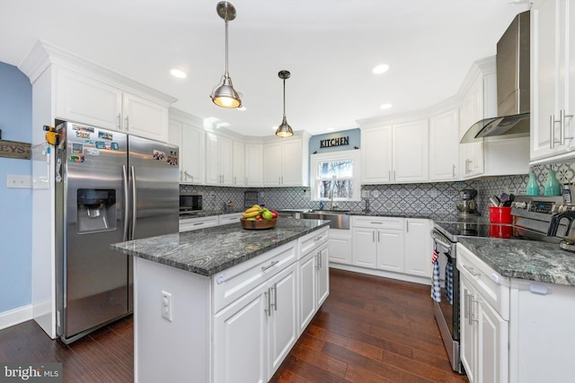 kitchen with dark wood finished floors, white cabinets, appliances with stainless steel finishes, and wall chimney exhaust hood