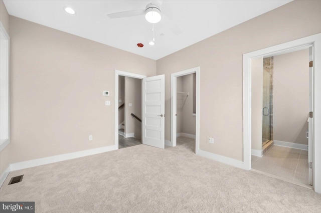 unfurnished bedroom featuring carpet floors, a spacious closet, a closet, and baseboards