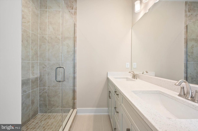 bathroom featuring a shower stall, baseboards, and a sink