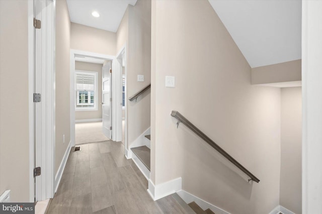 hallway with visible vents, baseboards, wood finished floors, and recessed lighting