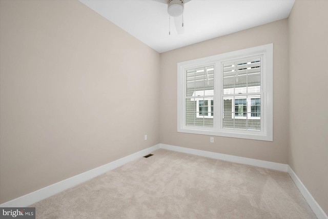 unfurnished room with carpet, visible vents, ceiling fan, and baseboards