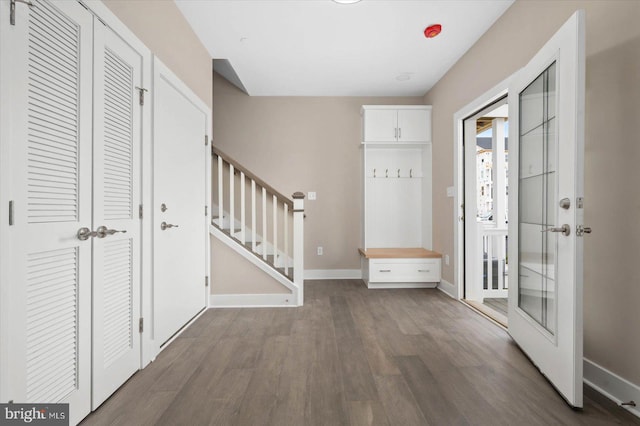 mudroom with dark wood finished floors and baseboards