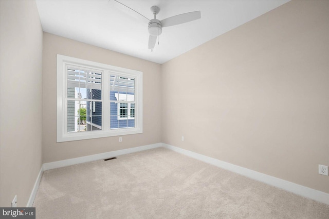 spare room featuring carpet floors, visible vents, and baseboards