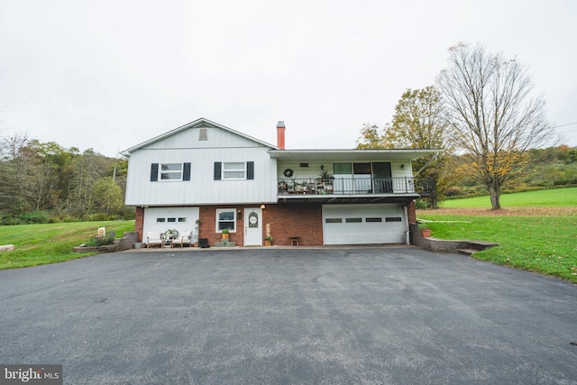 view of front of home featuring aphalt driveway, a balcony, brick siding, and a garage