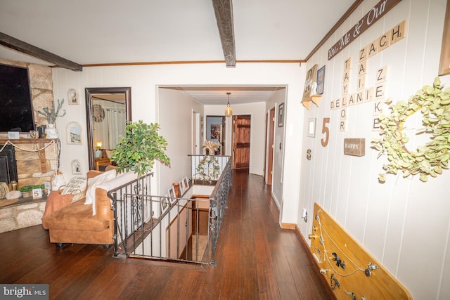 hallway with an upstairs landing, beam ceiling, dark wood-style flooring, and crown molding