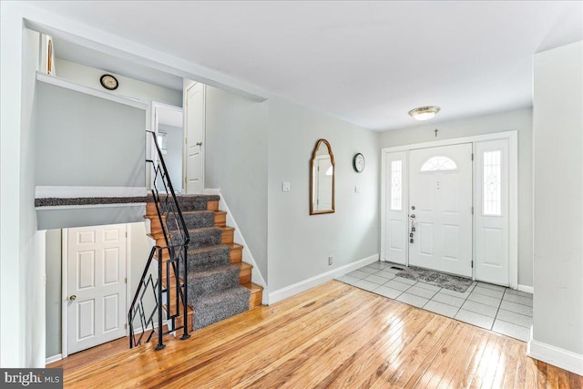 foyer entrance featuring baseboards, hardwood / wood-style floors, and stairs