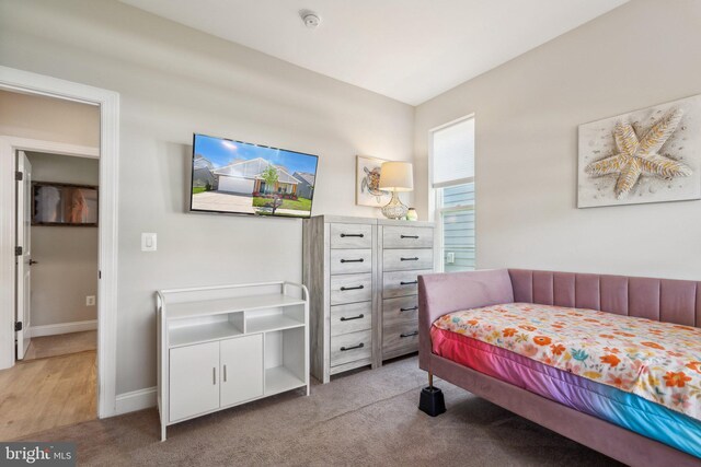 bedroom featuring baseboards and light colored carpet