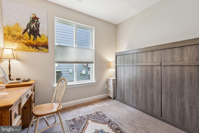home office with baseboards and light carpet