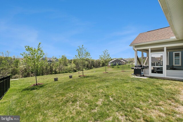 view of yard featuring fence and a sunroom