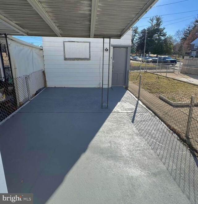 view of patio / terrace with a carport and fence