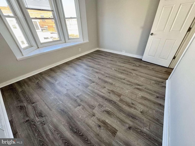 interior space featuring dark wood-type flooring and baseboards