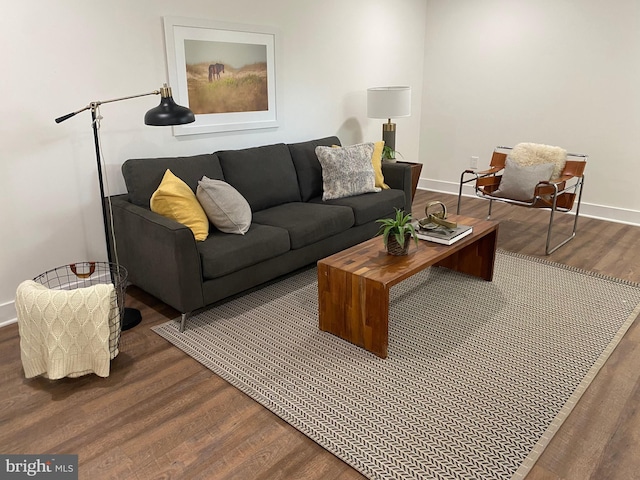 living area with baseboards and dark wood-style flooring