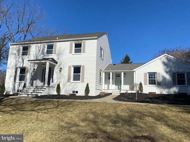 view of front of house with a front yard and brick siding