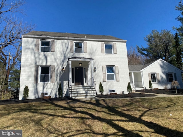 view of front of property featuring a front lawn and brick siding