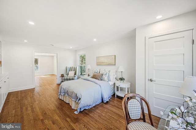 bedroom featuring baseboards, wood finished floors, and recessed lighting