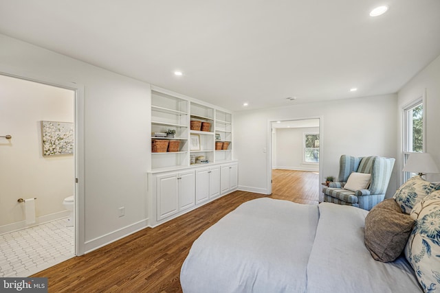 bedroom with ensuite bath, baseboards, dark wood-style flooring, and recessed lighting