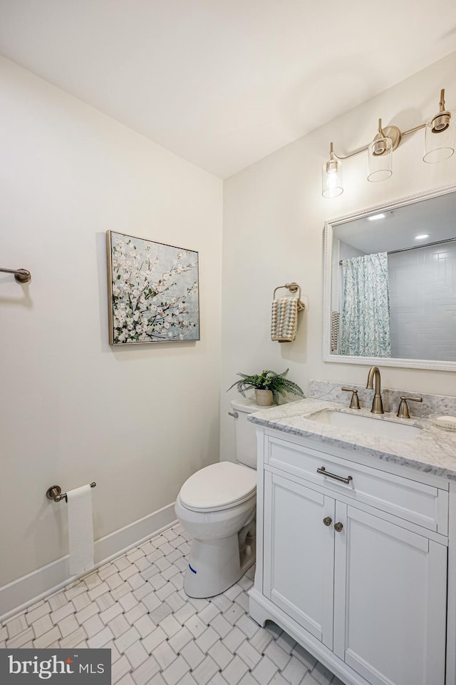 bathroom with toilet, curtained shower, vanity, and baseboards