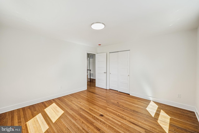 empty room with light wood-type flooring and baseboards