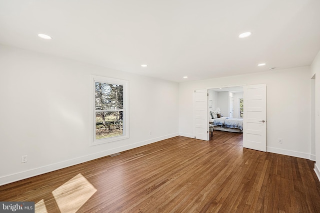 interior space with hardwood / wood-style floors, recessed lighting, visible vents, and baseboards