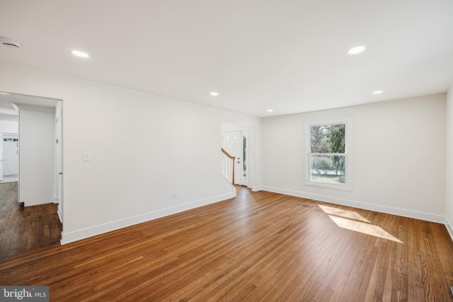 spare room with recessed lighting, stairway, baseboards, and hardwood / wood-style flooring