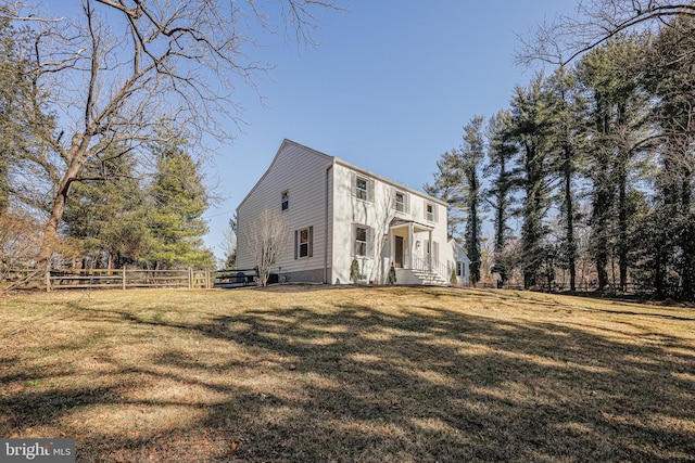 view of front of home with a front yard and fence