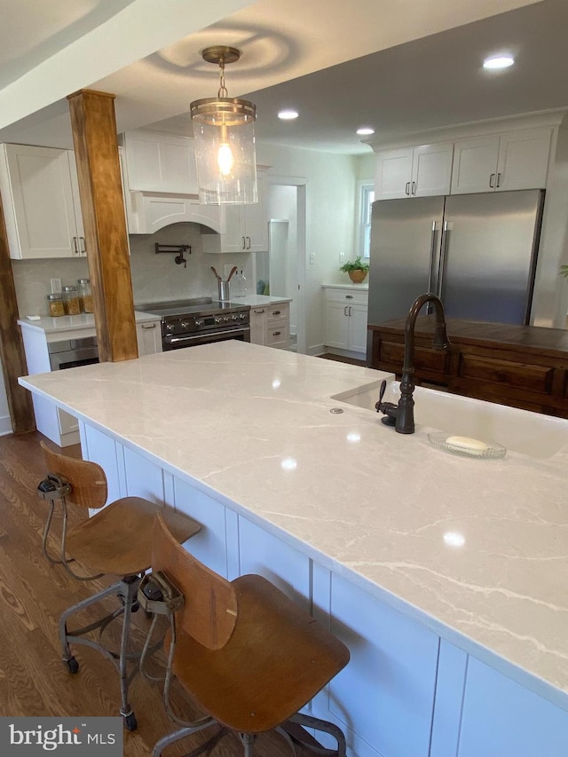 kitchen with appliances with stainless steel finishes, white cabinets, light countertops, and a sink