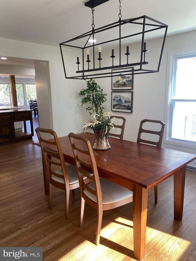 dining room featuring a healthy amount of sunlight, visible vents, and wood finished floors