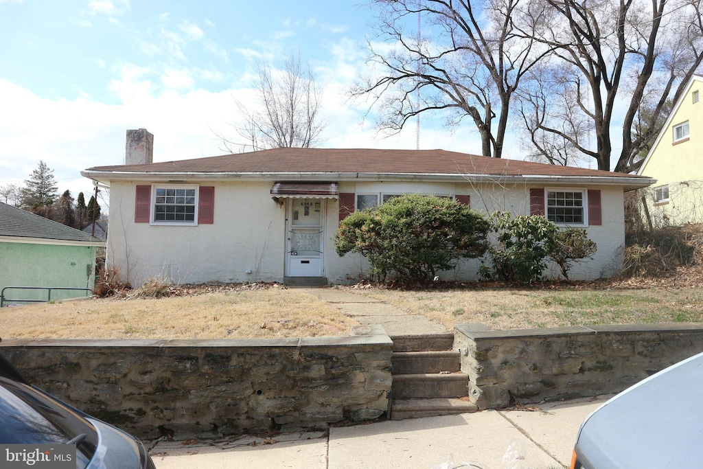 view of front of home with a chimney and stucco siding