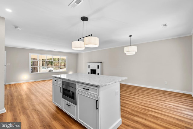 kitchen featuring visible vents, baseboards, light wood-style floors, and open floor plan