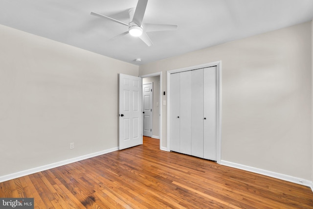 unfurnished bedroom featuring a closet, baseboards, ceiling fan, and hardwood / wood-style flooring